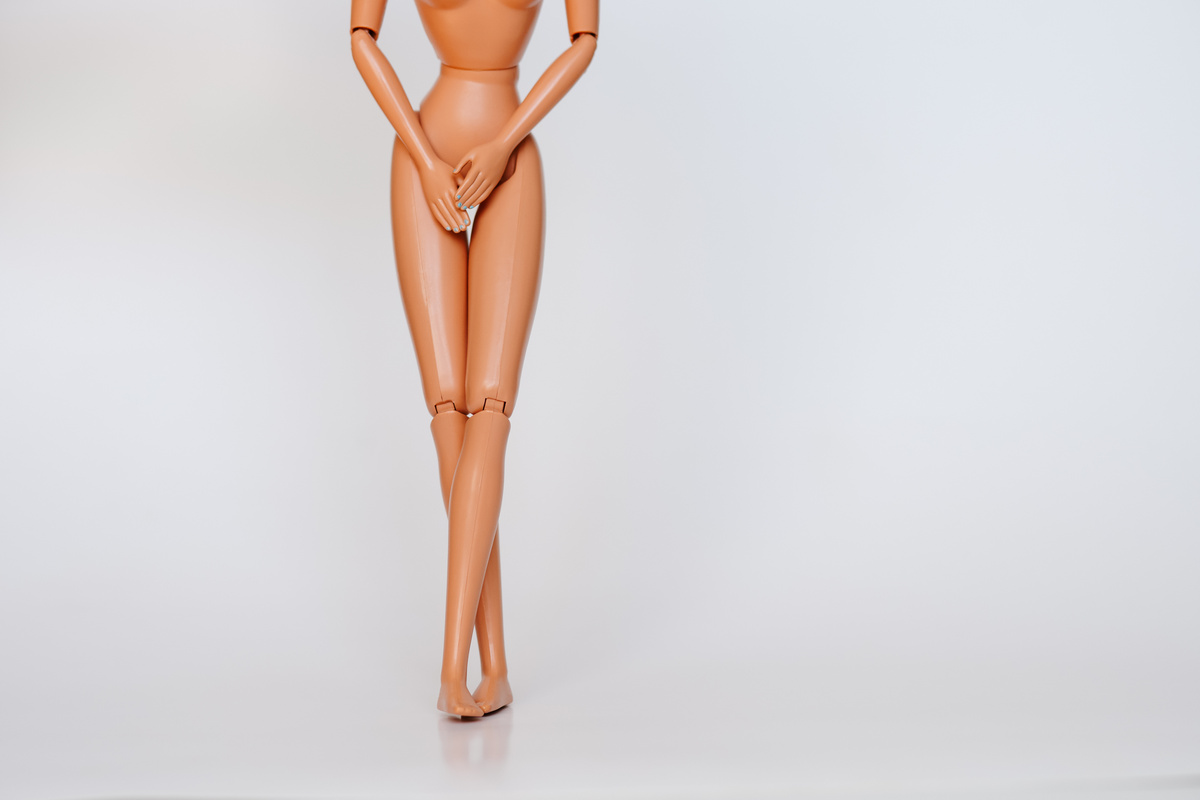 Nude Doll Covering Pelvic Area White Background